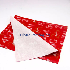 Emballage de cadeau de Noël emballant l'enveloppe rouge de papier de soie de soie avec l'impression de feuille d'or florale