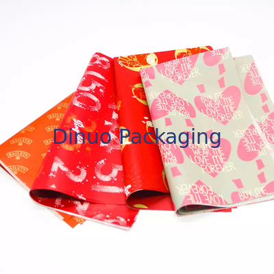 Emballage de cadeau de Noël emballant l'enveloppe rouge de papier de soie de soie avec l'impression de feuille d'or florale