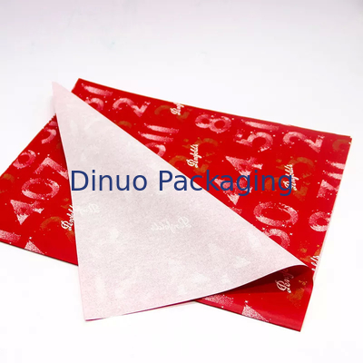 Emballage de cadeau de Noël emballant l'enveloppe rouge de papier de soie de soie avec l'impression de feuille d'or florale